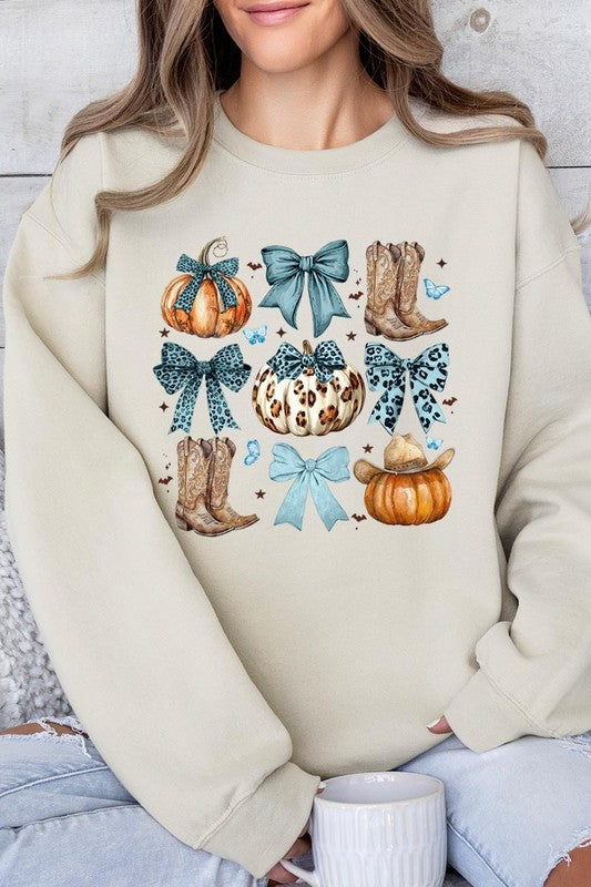 A woman is wearing a high-quality Turquoise Bow Western Fall Fleece Sweatshirt in olive green, featuring pumpkins, cowboy boots, a hat, and turquoise bows. She is seated on a gray, textured surface and wears light blue ripped jeans.