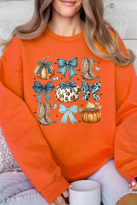 A woman is wearing a high-quality Turquoise Bow Western Fall Fleece Sweatshirt in olive green, featuring pumpkins, cowboy boots, a hat, and turquoise bows. She is seated on a gray, textured surface and wears light blue ripped jeans.