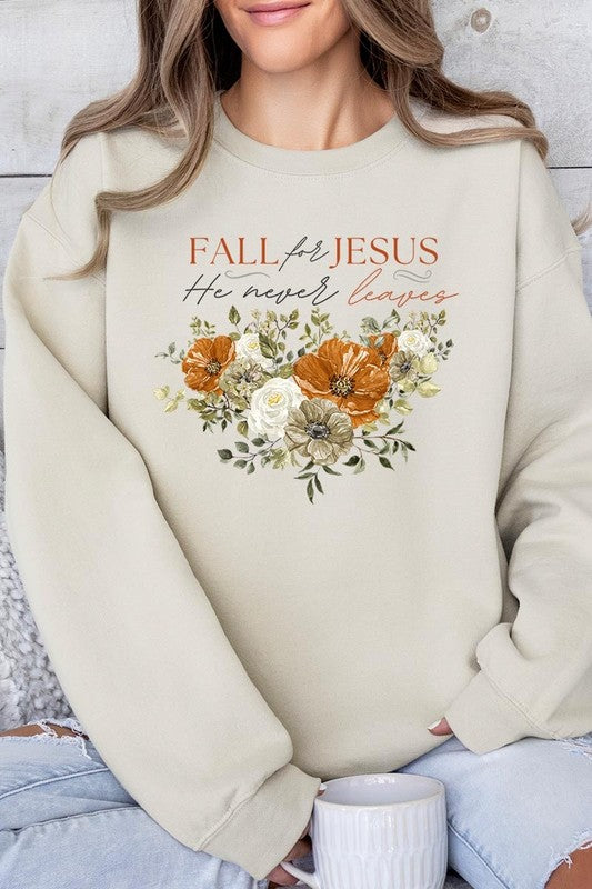 A person wearing a beige "Fall For Jesus He Never Leaves Fleece Sweatshirt" featuring a floral design and the text "FALL for JESUS He never leaves." This unisex crew neck fleece makes an excellent family group gift.