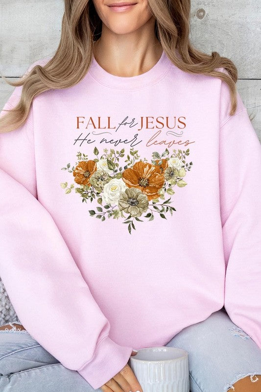 A person wearing a beige "Fall For Jesus He Never Leaves Fleece Sweatshirt" featuring a floral design and the text "FALL for JESUS He never leaves." This unisex crew neck fleece makes an excellent family group gift.