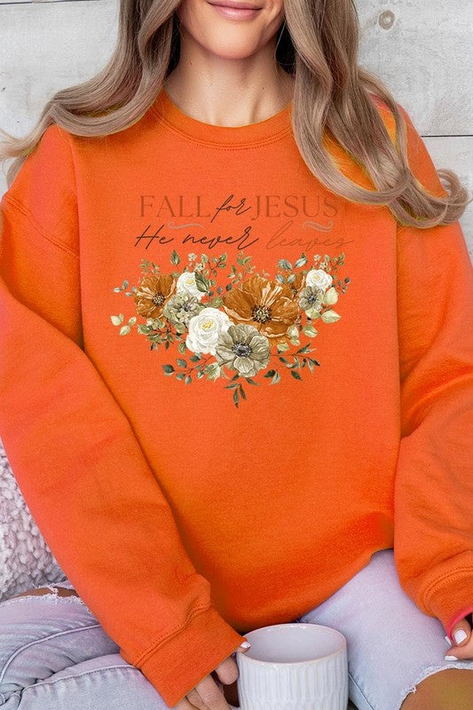 A person wearing a beige "Fall For Jesus He Never Leaves Fleece Sweatshirt" featuring a floral design and the text "FALL for JESUS He never leaves." This unisex crew neck fleece makes an excellent family group gift.