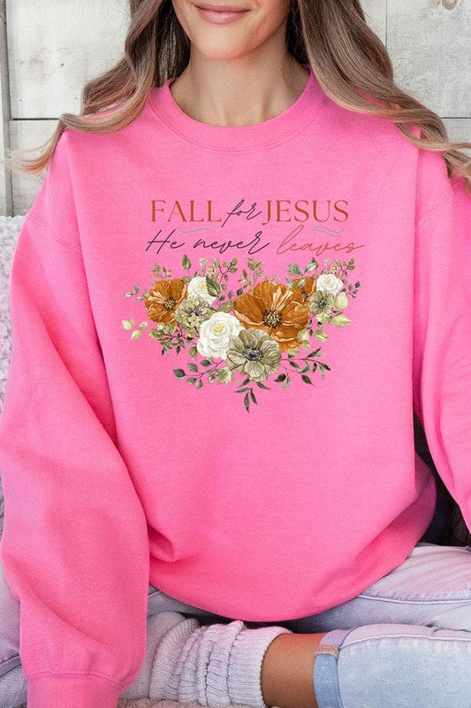 A person wearing a beige "Fall For Jesus He Never Leaves Fleece Sweatshirt" featuring a floral design and the text "FALL for JESUS He never leaves." This unisex crew neck fleece makes an excellent family group gift.