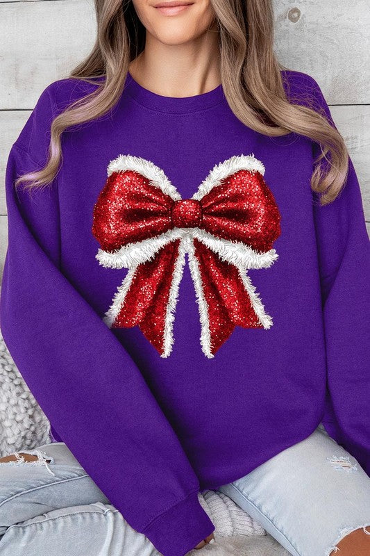 Person wearing a Christmas Santa Bow Graphic Fleece Sweatshirt in dark green, showcasing a large, glittery red and white Santa bow graphic on the front.