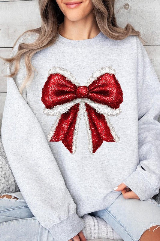 Person wearing a Christmas Santa Bow Graphic Fleece Sweatshirt in dark green, showcasing a large, glittery red and white Santa bow graphic on the front.