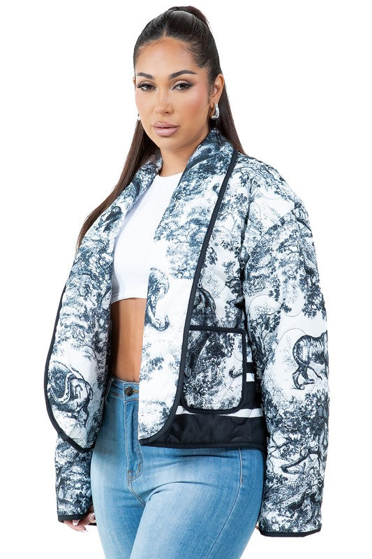 A woman stands facing forward wearing the WOMEN FASHION PUFFER JACKET, which features a blue and white pattern and a stand collar, giving an oversized look. She is also dressed in a white cropped top, blue jeans, and black ankle boots.