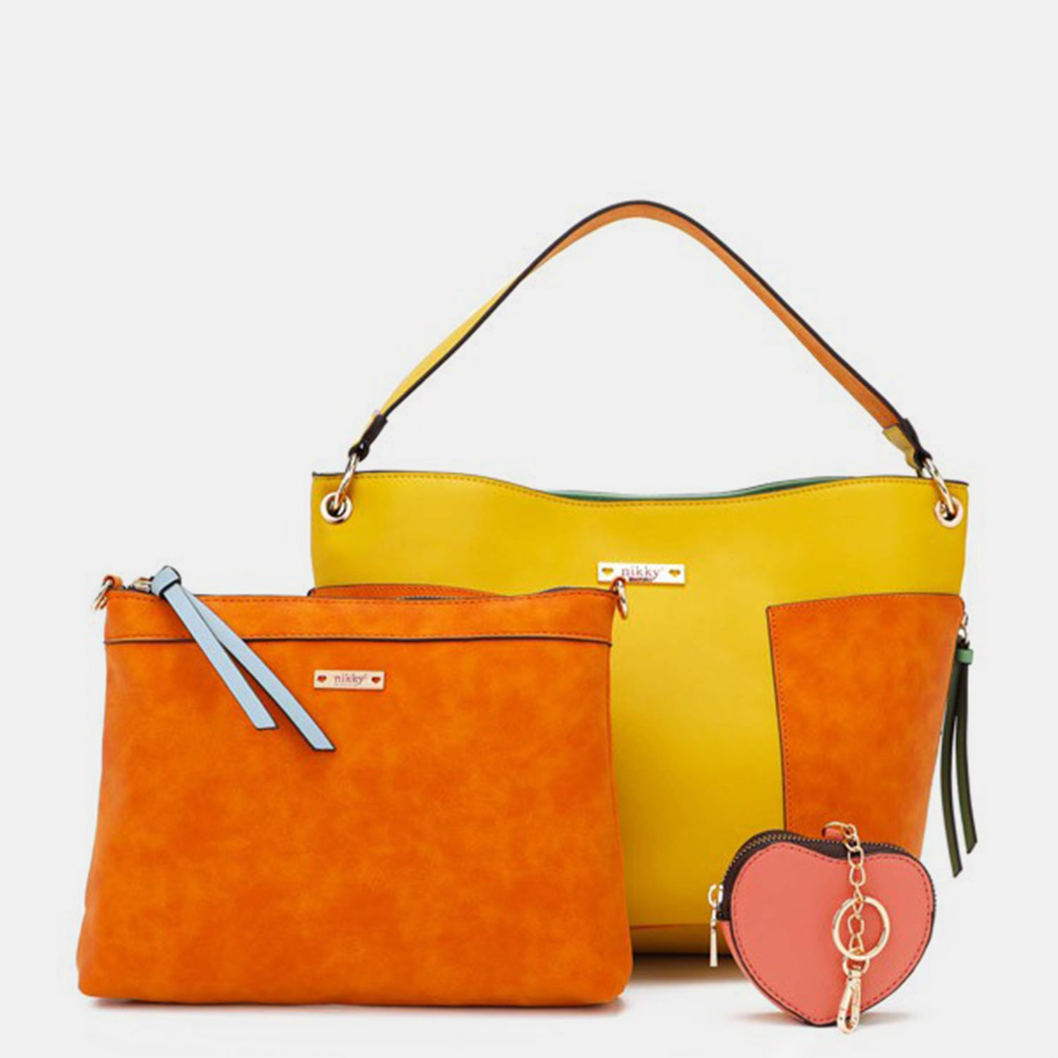 The Nicole Lee USA 3-Piece Handbag Set features a yellow handbag, an orange clutch with a blue zipper, and a heart-shaped orange coin purse with a keychain, all beautifully displayed against a white background. This stylish satchel collection is perfect for any occasion, adding flair to your ensemble.