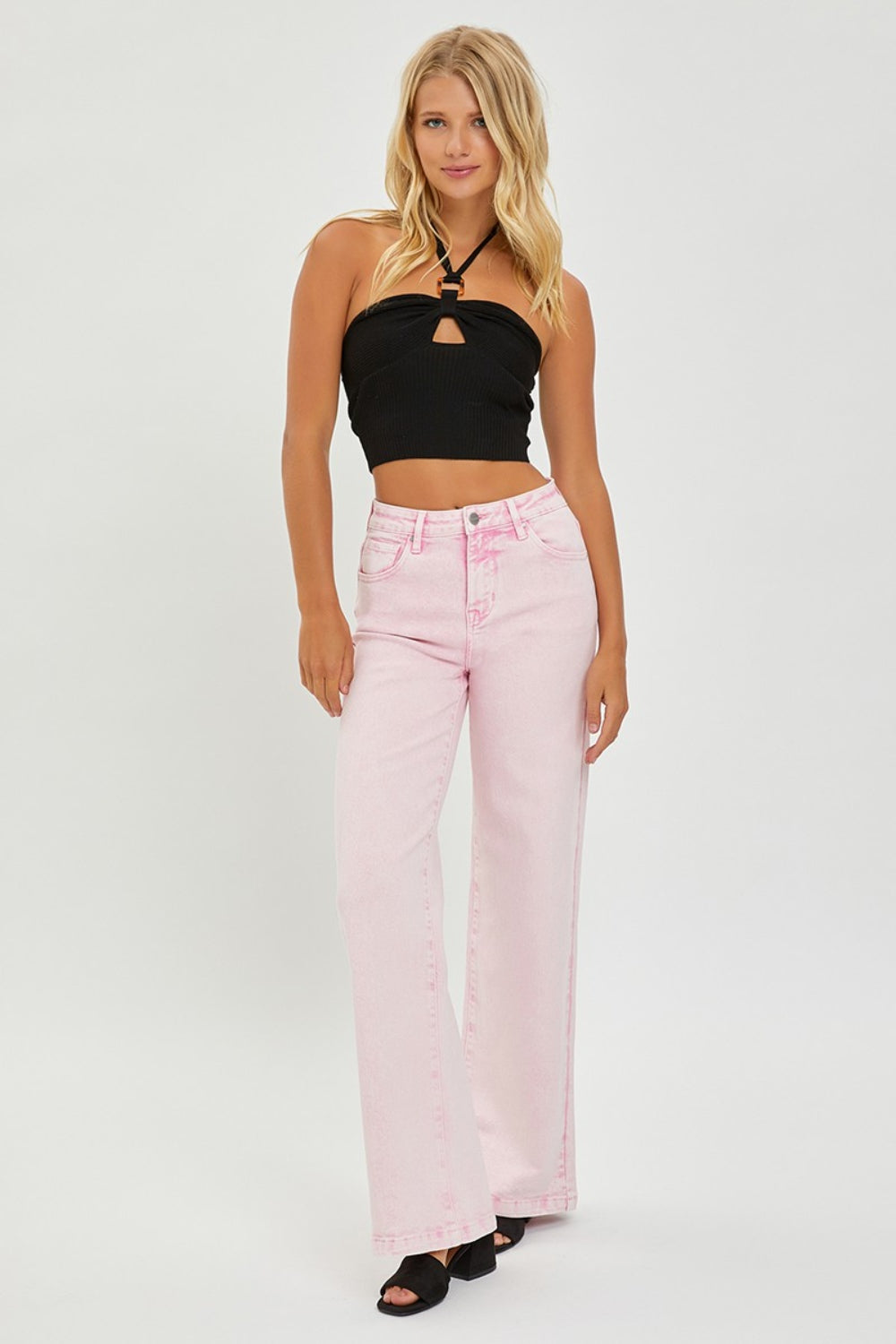 Someone is wearing RISEN Full Size High Rise Tummy Control Wide Leg Jeans in light pink, paired with black heeled sandals against a plain white background.