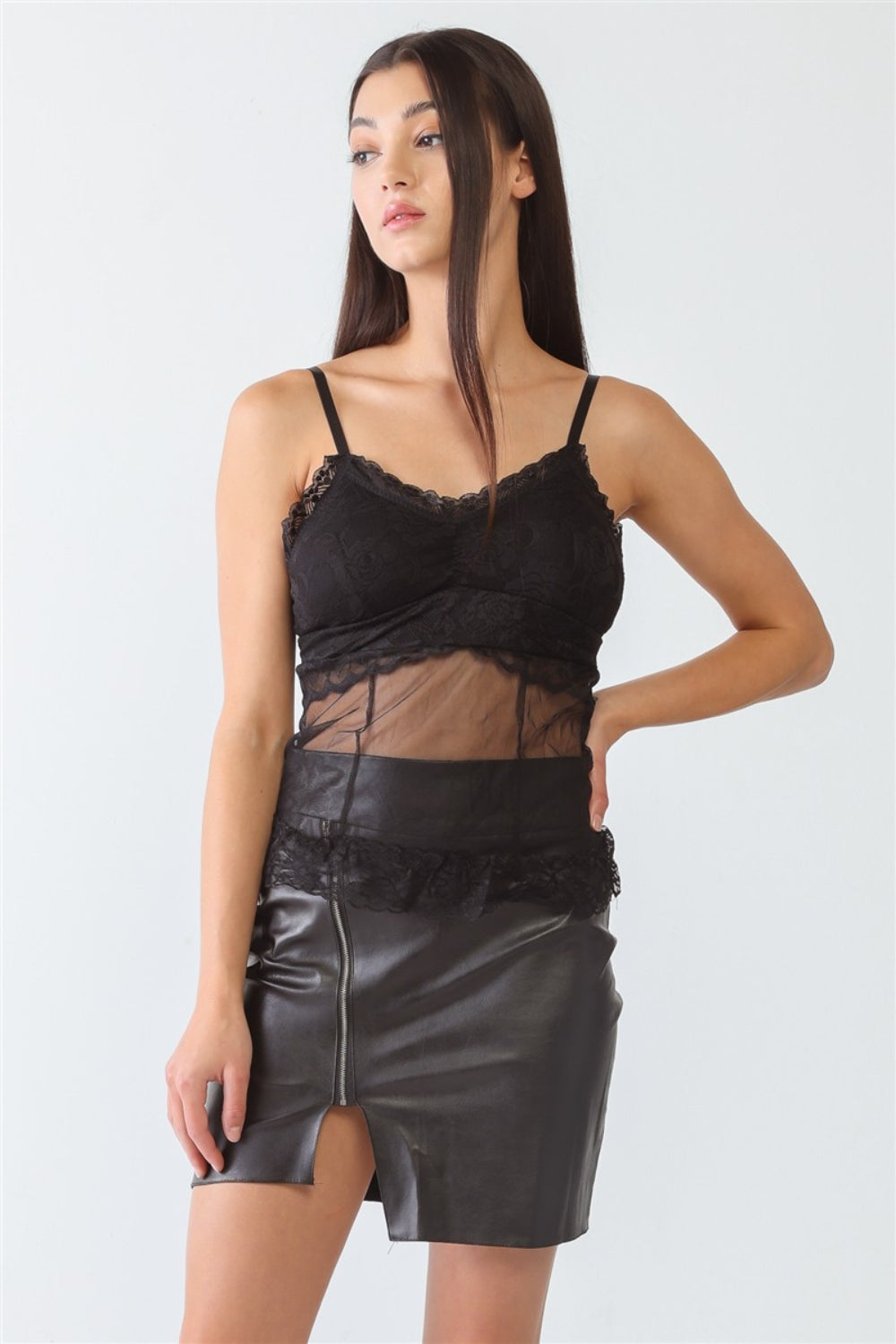 A woman stands wearing a FASHION4YOU Sheer Mesh Lace Push-Up Bustier and a black leather skirt with a front slit against a plain background.