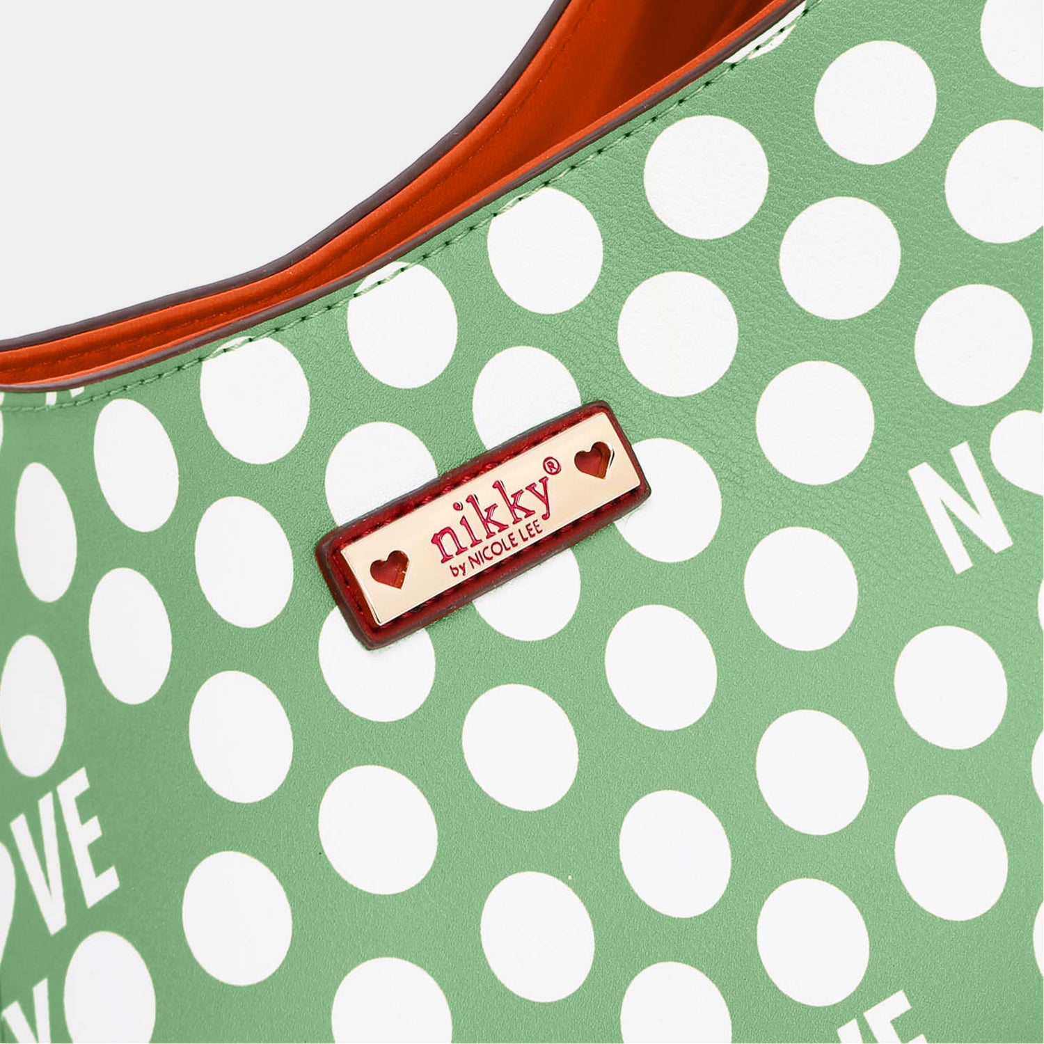 Nicole Lee USA Contrast Polka Dot Handbag made of vegan leather, featuring a green and white polka dot design, an "I LOVE NIKKY" text pattern, and a vibrant orange interior lining.