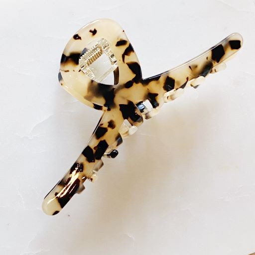 Two different colored Barely There Hair Claws placed on a light-colored surface.