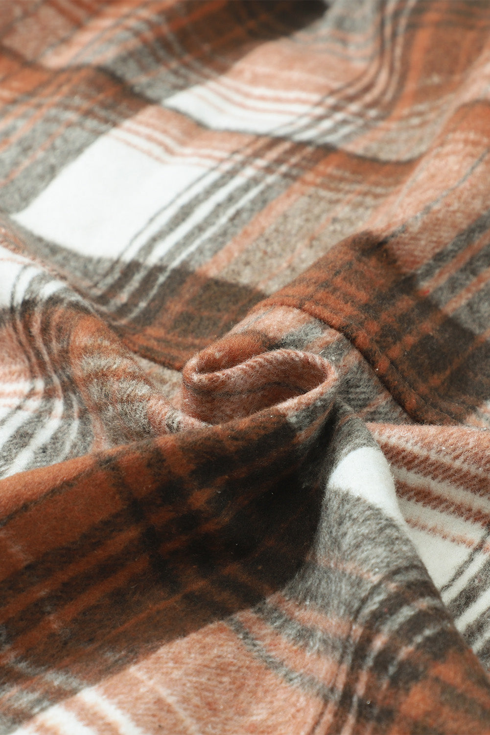 A woman wearing a white top, blue jeans, and the Gold Flame & Grey Plaid Button Up Collared Flannel Shacket smiles while posed outdoors.