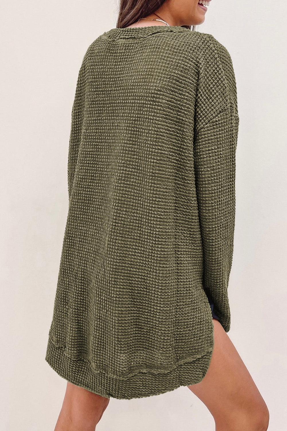 Person wearing a trendy Green Waffle Knit Drop Sleeve High Slits Oversized Top takes a mirror selfie, showcasing the cozy waffle knit texture along with their upper and part of their lower body.