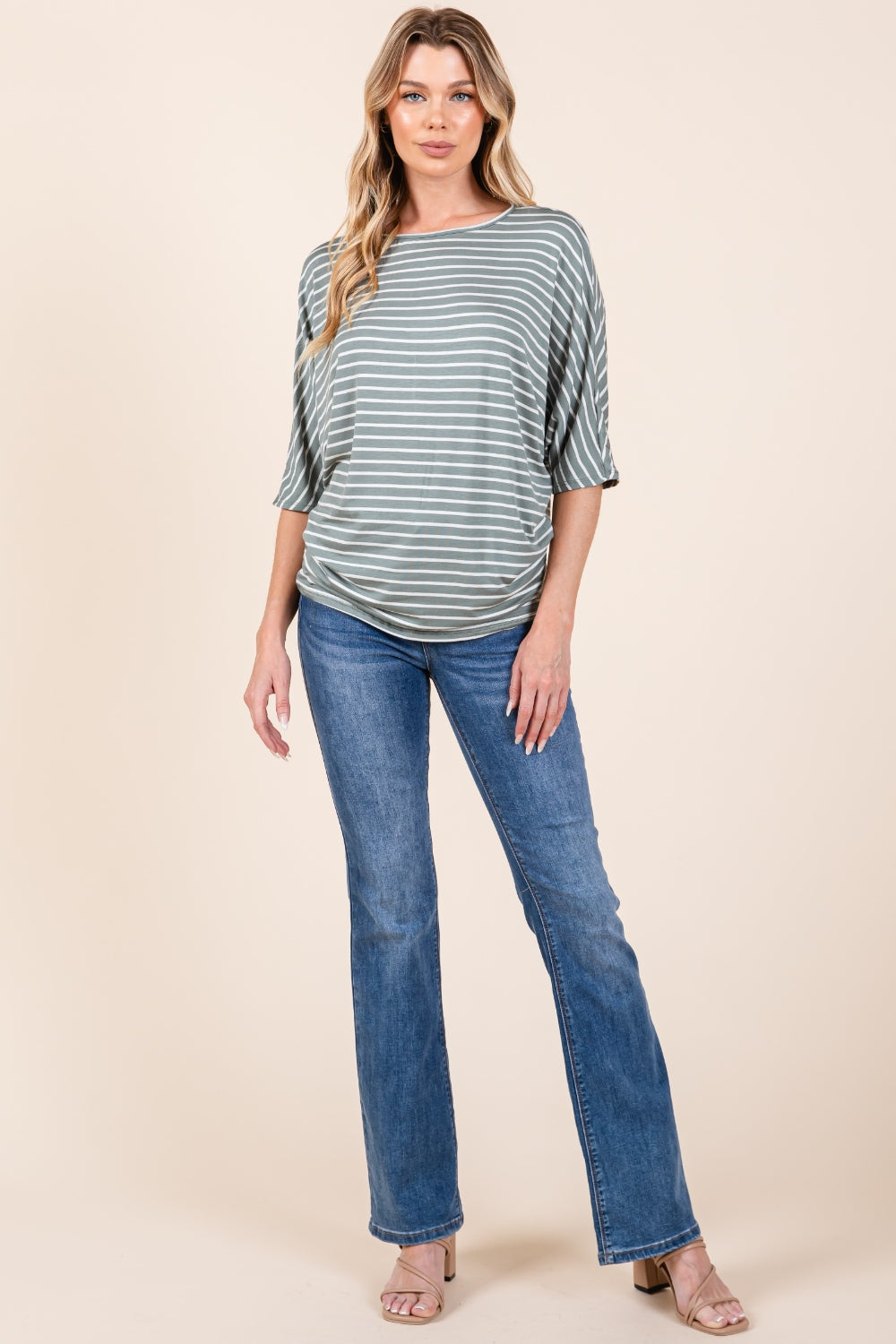 A person with long, wavy hair wearing the BOMBOM Striped Boat Neck Dolman Sleeve Top and blue jeans poses against a plain background.