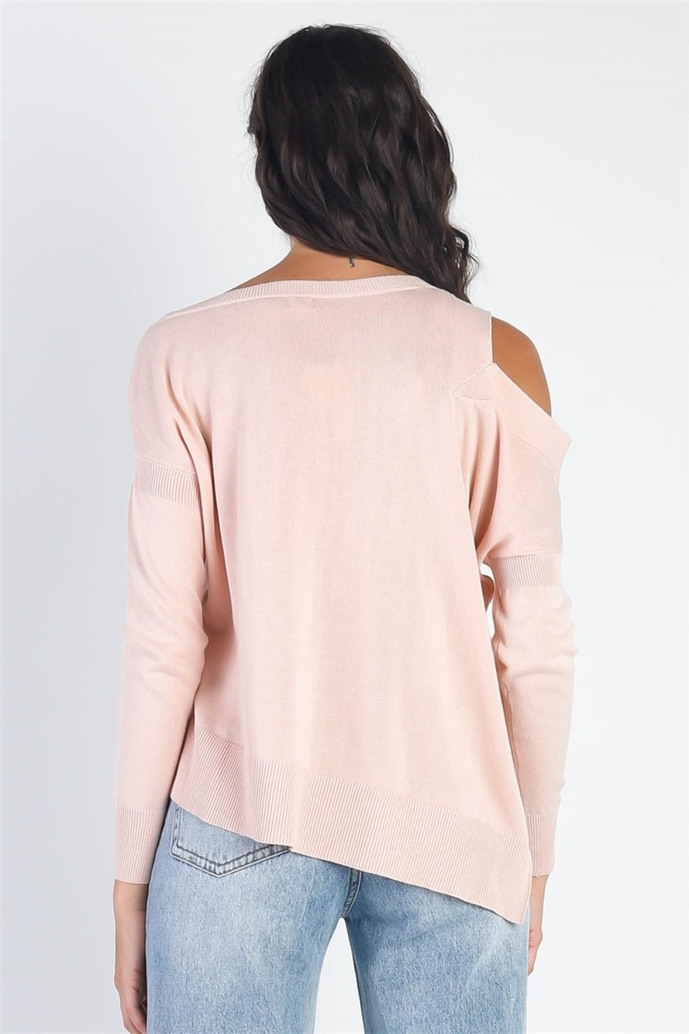 A person wearing the UNIQ Cold Shoulder Long Sleeve Knit Top in black and distressed denim shorts stands against a plain white background, effortlessly showcasing a versatile wardrobe choice.