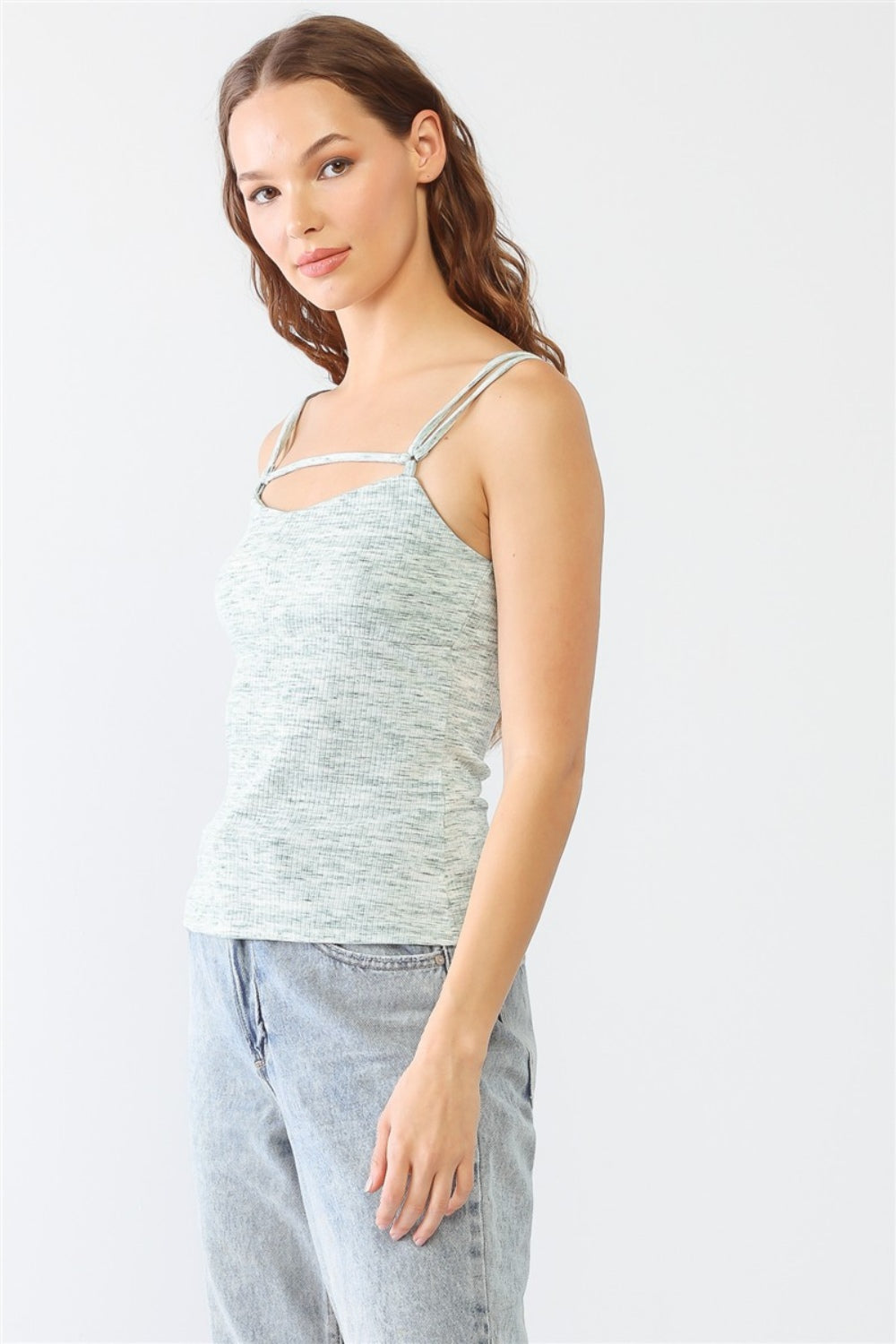 Dressed in a stylish Le Lis Heathered Ribbed Adjustable Strap Cami, a person stands against a plain background, paired with jeans.