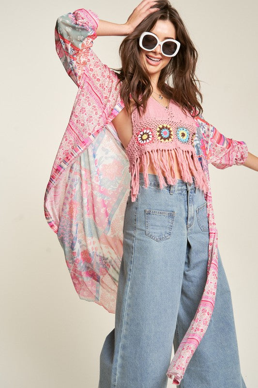 A person wearing round sunglasses and the Mesh Print Mix Matched Button Front Cover Up featuring pink, red, and white tones stands against a plain background over blue jeans.