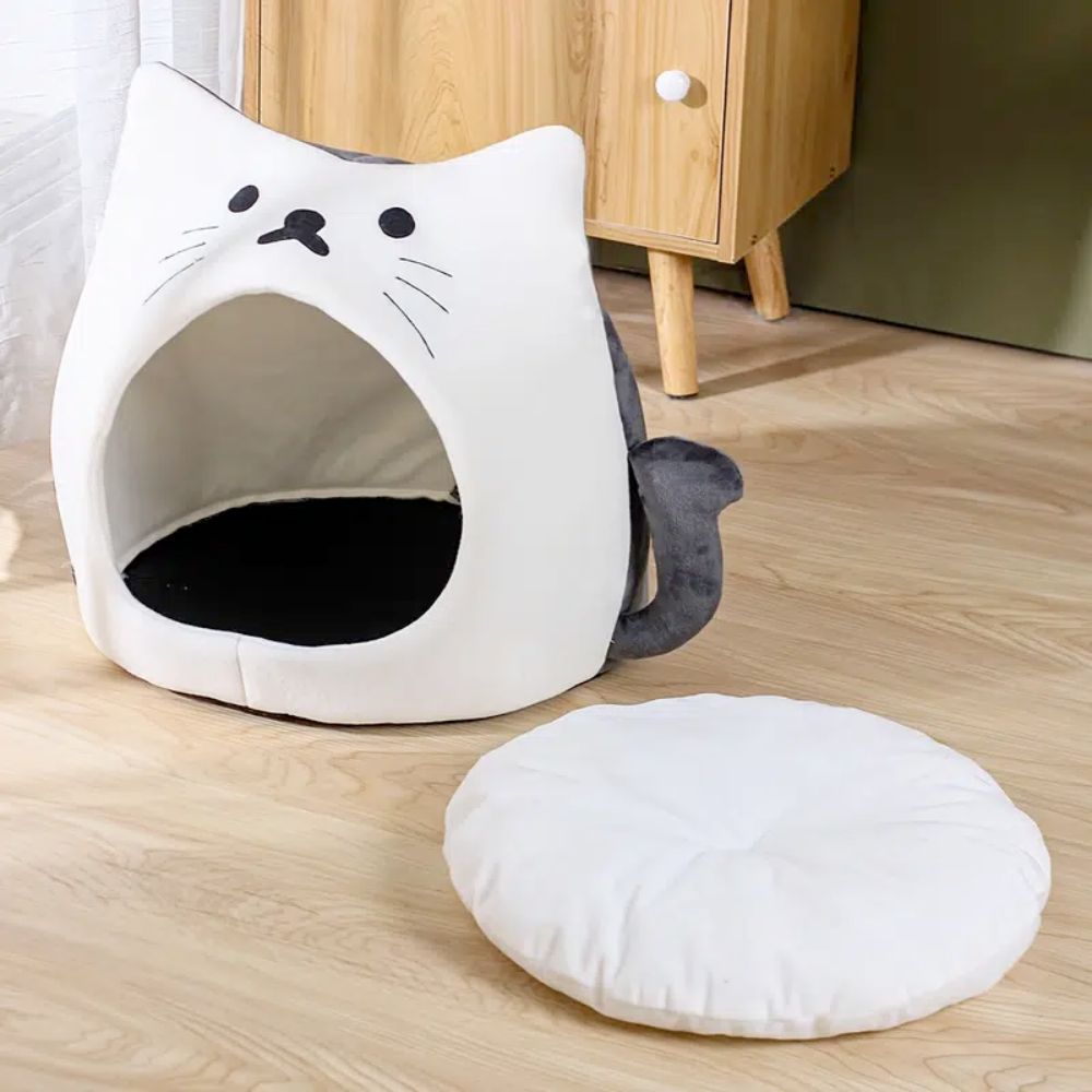 An Adorable Cat Shape Pet House nestled in a cozy pet house designed like a cat shape bed, enjoying the soft spot.
