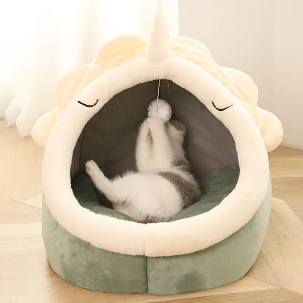An Adorable Dinosaur Pet House with Toy has a toy unicorn for the cat to play with.