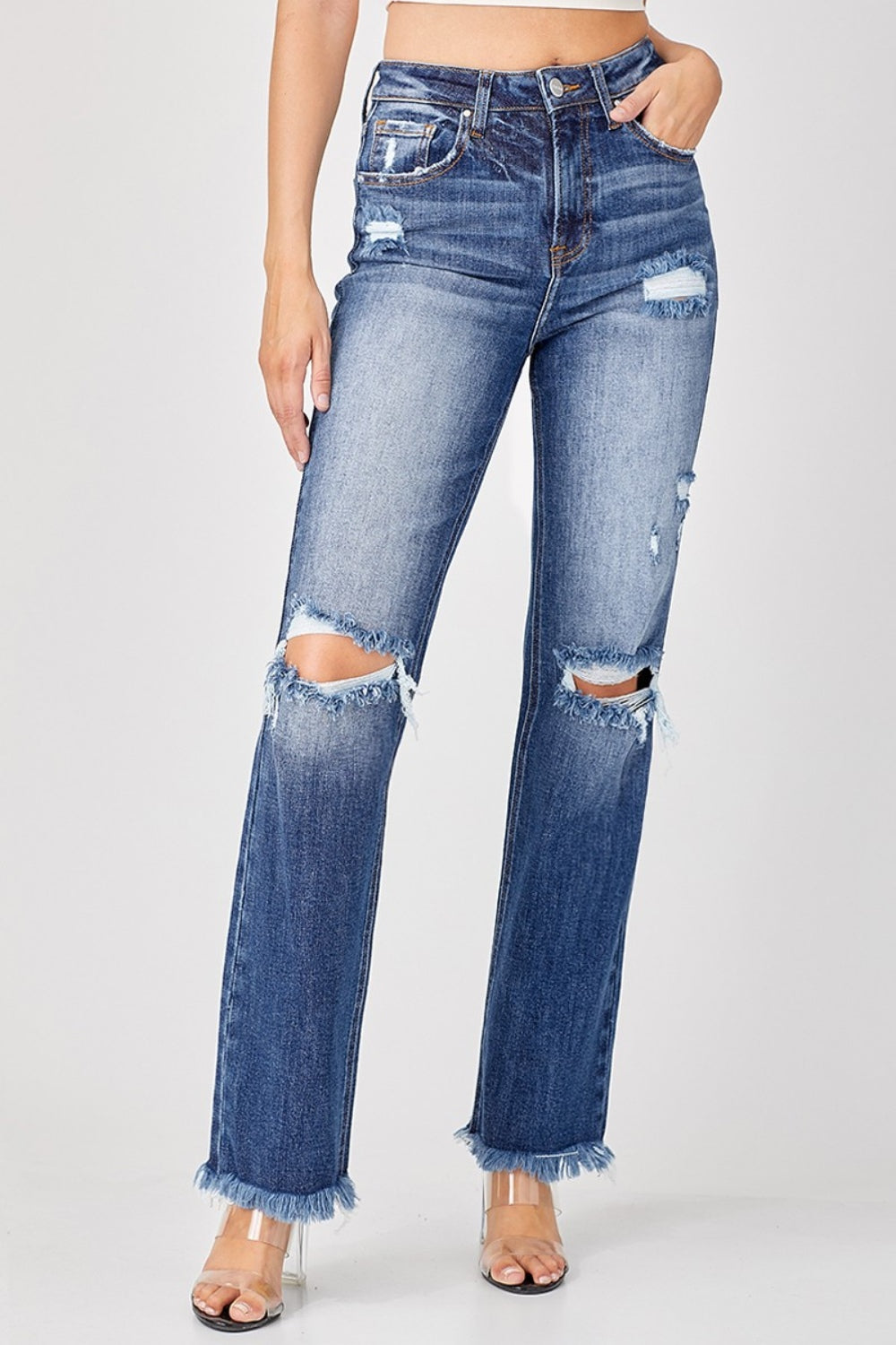 A person is wearing the Risen Full Size Raw Hem Distressed Straight Jeans paired with clear heels.