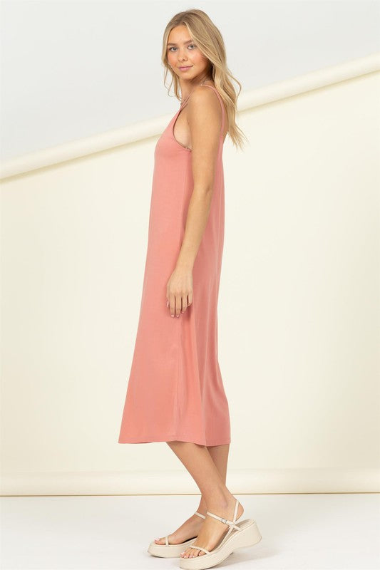 A person in the Make It Right Sleeveless Maxi Dress, known for its relaxed fit and pink hue, poses gracefully against a plain background.