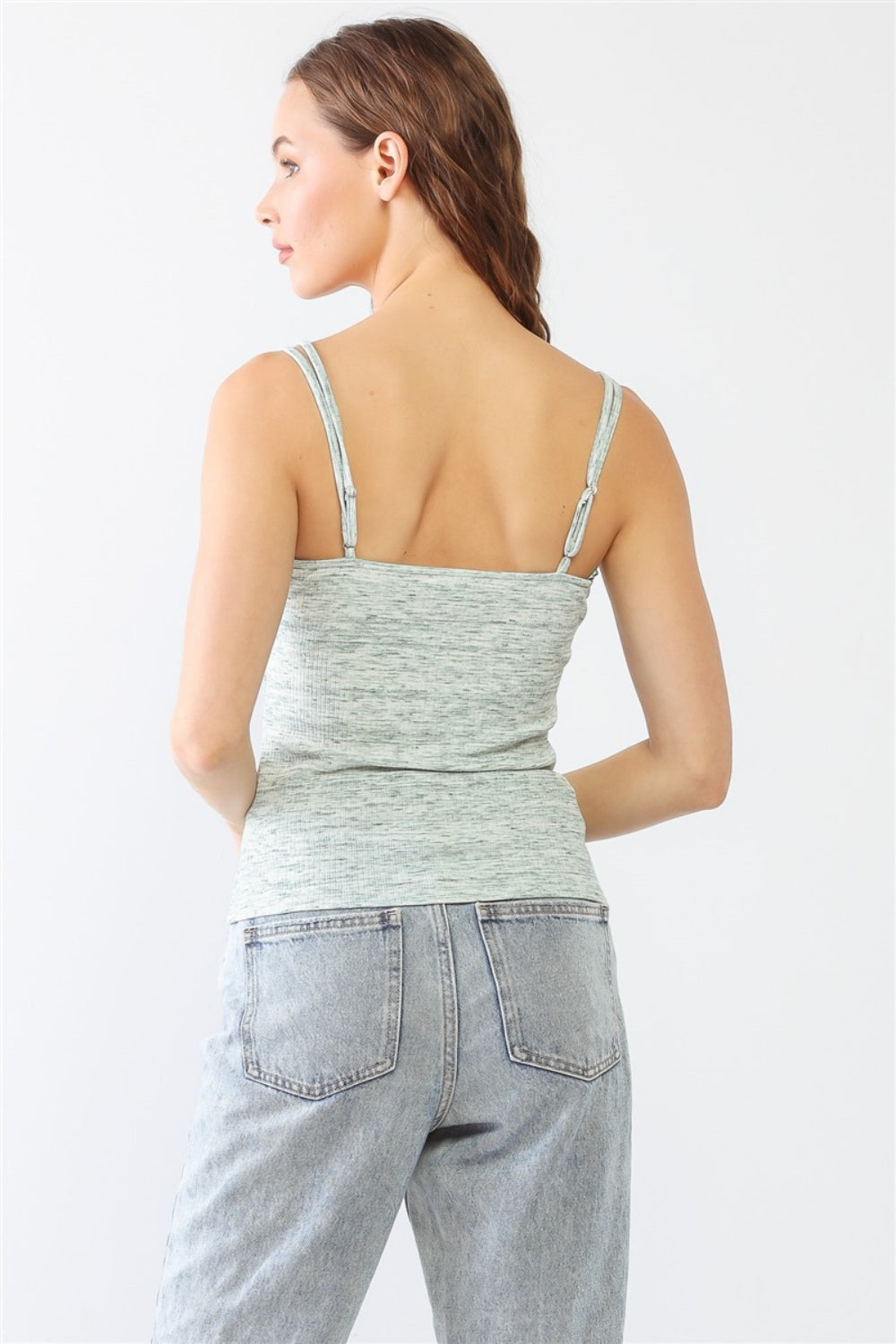 Dressed in a stylish Le Lis Heathered Ribbed Adjustable Strap Cami, a person stands against a plain background, paired with jeans.