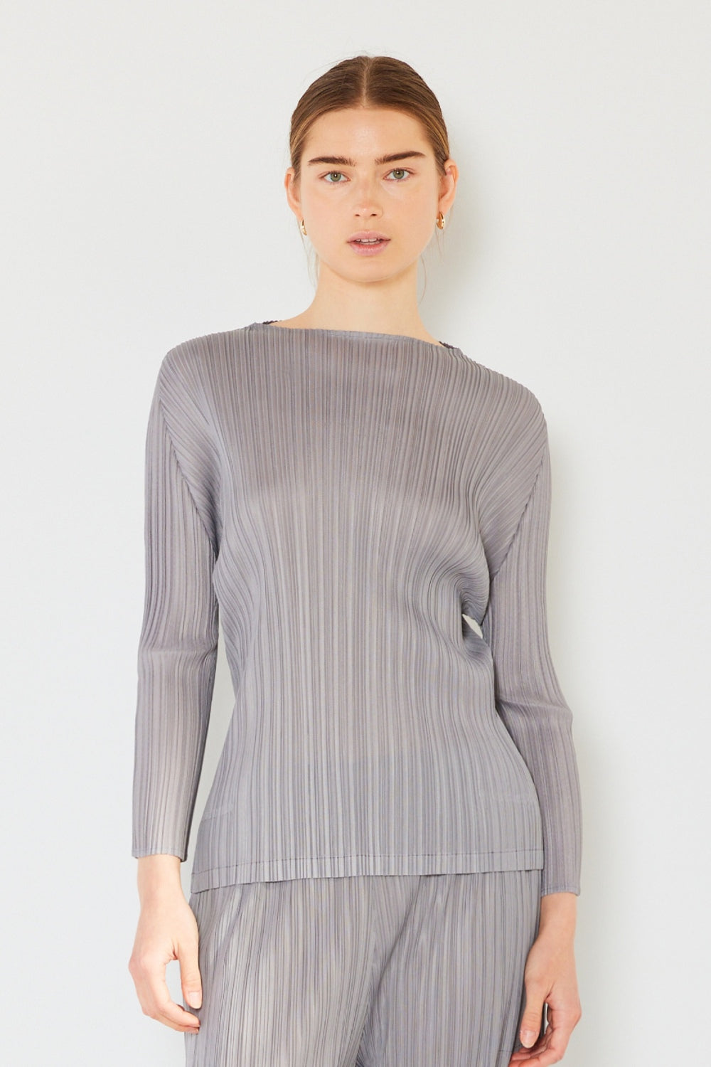 A person wearing the Marina West Swim Pleated Long Sleeve Boatneck Top with matching pants stands against a plain background.