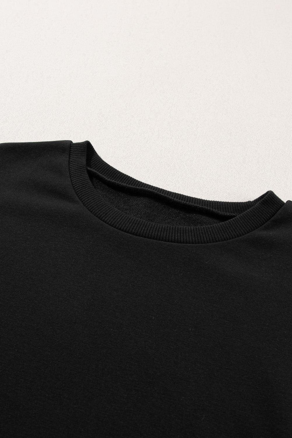 A person is standing with their back to the camera, wearing a Black Snap Buttons Side Splits Pullover Sweatshirt and white pants.