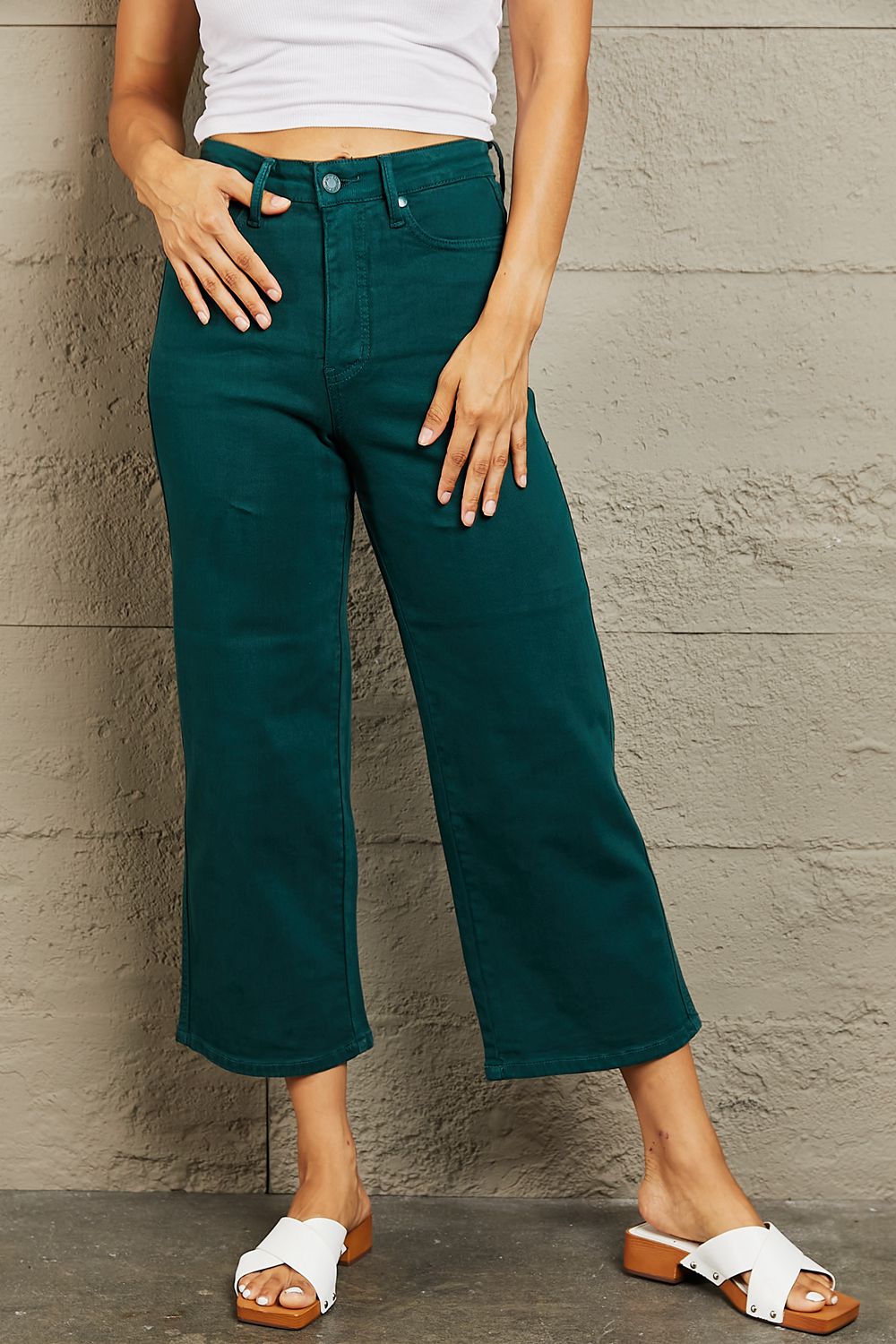 Person wearing Judy Blue Hailey Full Size Tummy Control High Waisted Cropped Wide Leg Jeans that offer subtle silhouette enhancement, paired with stylish white sandals.