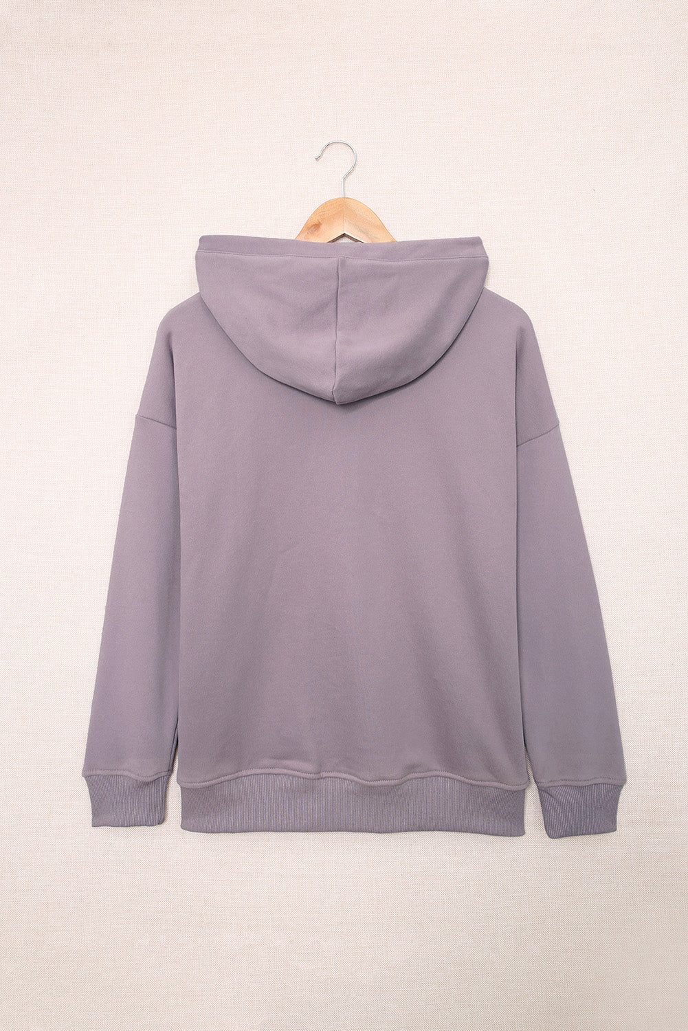 Back view of a person wearing a Purple Snap Button Pullover Hoodie with Pocket and light blue denim shorts with frayed hems, perfect for casual occasions, standing against a grey textured background.