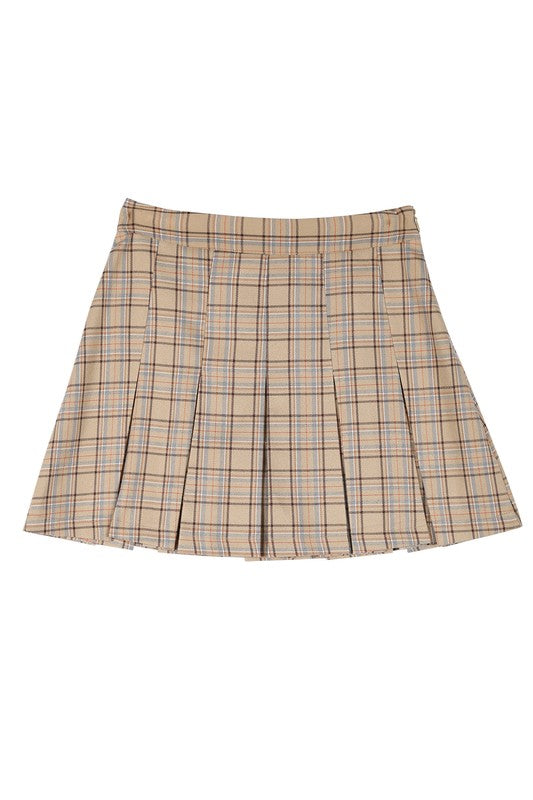 A person dressed in a plaid pleated mini skirt paired with a beige sweater is posed against a plain backdrop. This fashionable and versatile outfit, featuring the Plaid Pleated Mini Skirt, is designed for easy maintenance and can be machine washed in cold water.