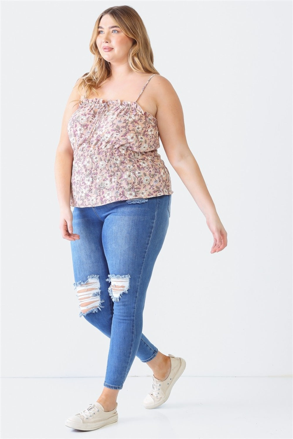 A person with long hair, wearing the Zenobia Plus Size Frill Floral Square Neck Cami and dark jeans, stands with one hand on their hip and the other relaxed by their side.