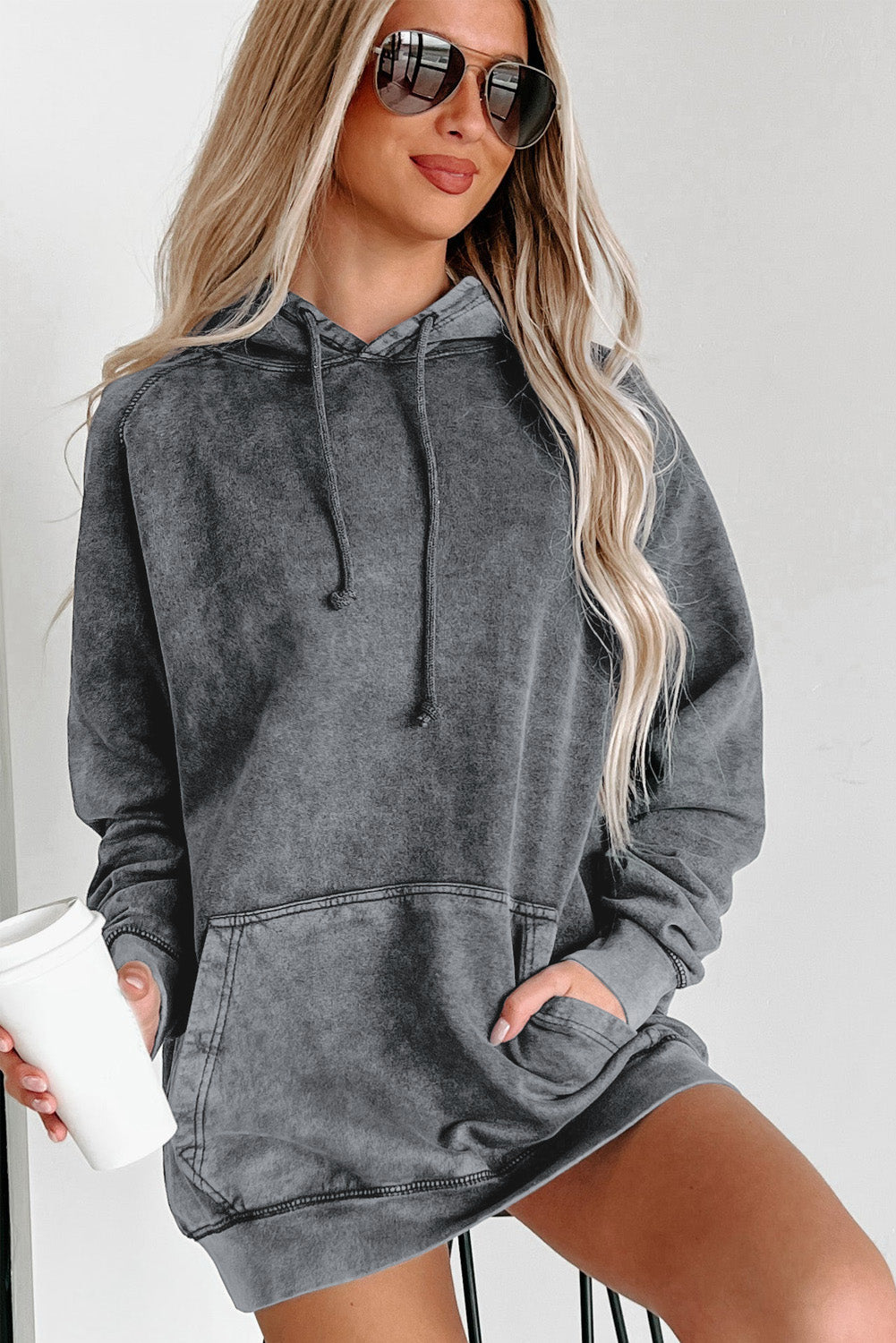 A person with blonde hair is standing with their back to the camera, wearing a Gray Mineral Wash Kangaroo Pocket Drawstring Pullover Hoodie.