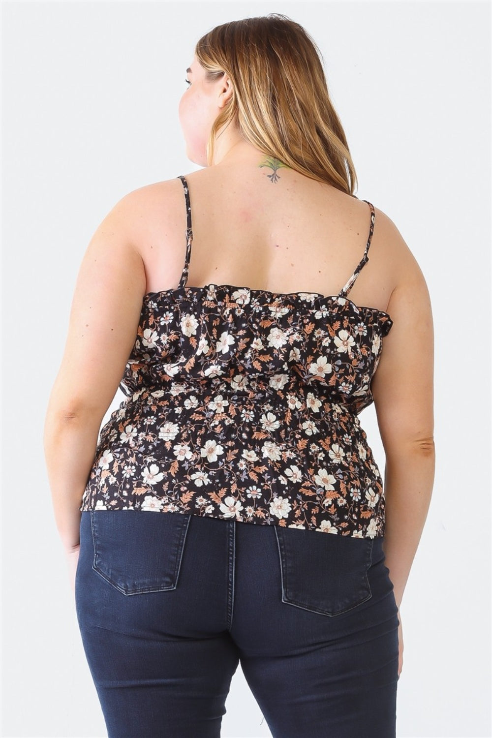 A person with long hair, wearing the Zenobia Plus Size Frill Floral Square Neck Cami and dark jeans, stands with one hand on their hip and the other relaxed by their side.