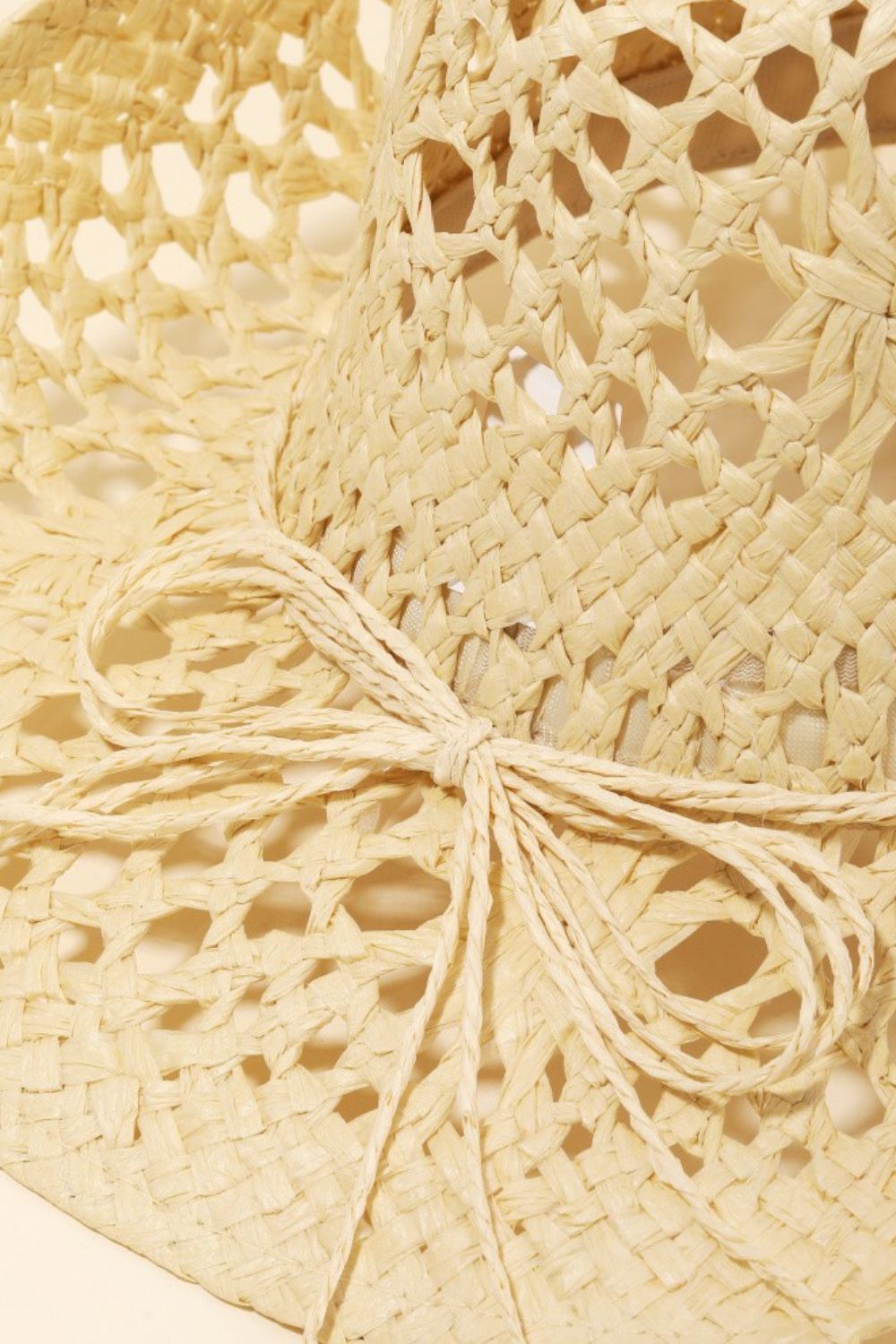 A wide-brimmed, light-colored Fame Straw Weave Rope Ribbon Cowboy Hat featuring intricate cutout designs.