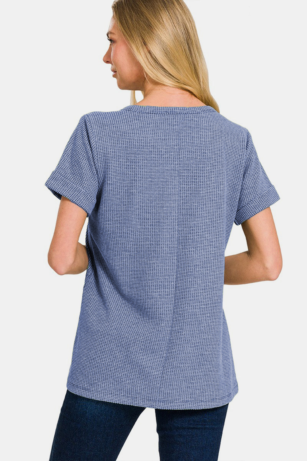 A person wearing a Zenana Notched Short Sleeve Waffle T-Shirt in blue and jeans stands against a plain background, capturing the essence of a casual wardrobe.