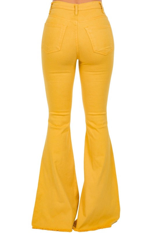 Person wearing the Bell Bottom Jean in Mustard with a 30-inch inseam, featuring a high-waisted fit and frayed hem.