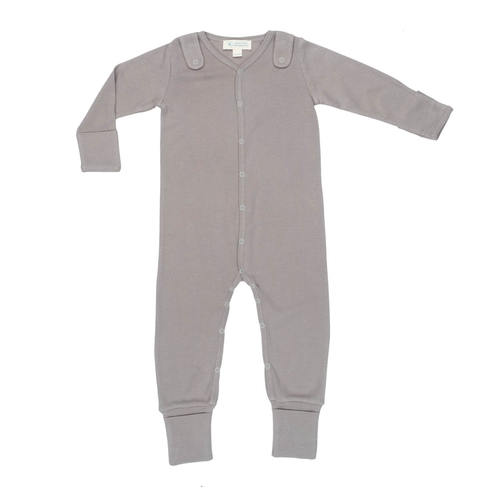 A baby is playing with the Smart Footed One-Piece + Bib - Gray by Fuchsia Milo in a living room.