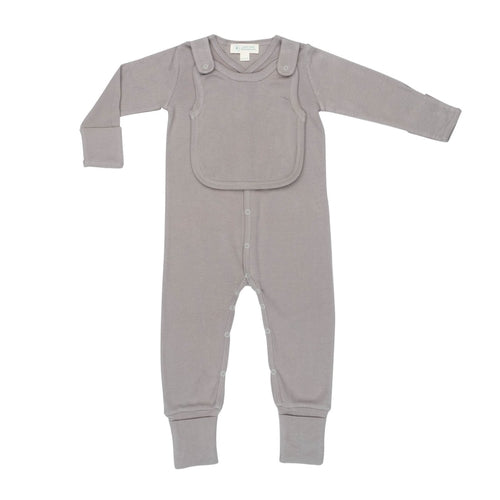 A baby is playing with the Smart Footed One-Piece + Bib - Gray by Fuchsia Milo in a living room.