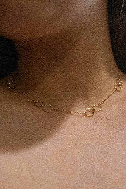 The Double Double Necklace is adorned with interlinked circular designs made from 14k gold-plated stainless steel and fastens with a lobster clasp.