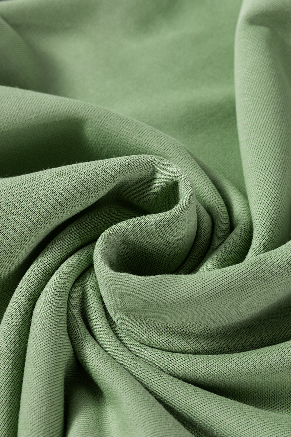 A person wearing a Grass Green Leopard Print Colorblock Raglan Sleeve Sweatshirt stands in front of a brick wall.