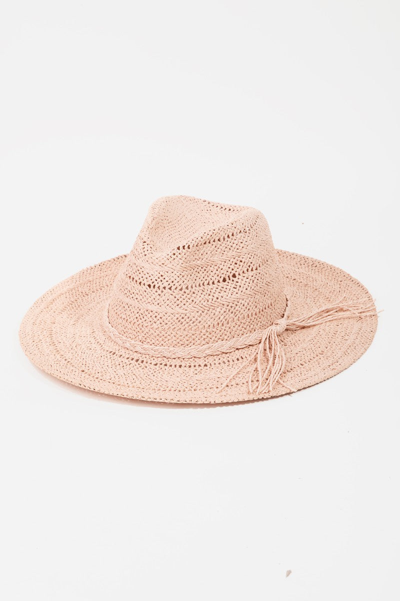 The Fame Braided Rope Straw Hat, in a charming pink color, is a perfect addition to your summer wardrobe. It features a wide brim and fringe detail around the crown, offering stylish sun protection against a light background.