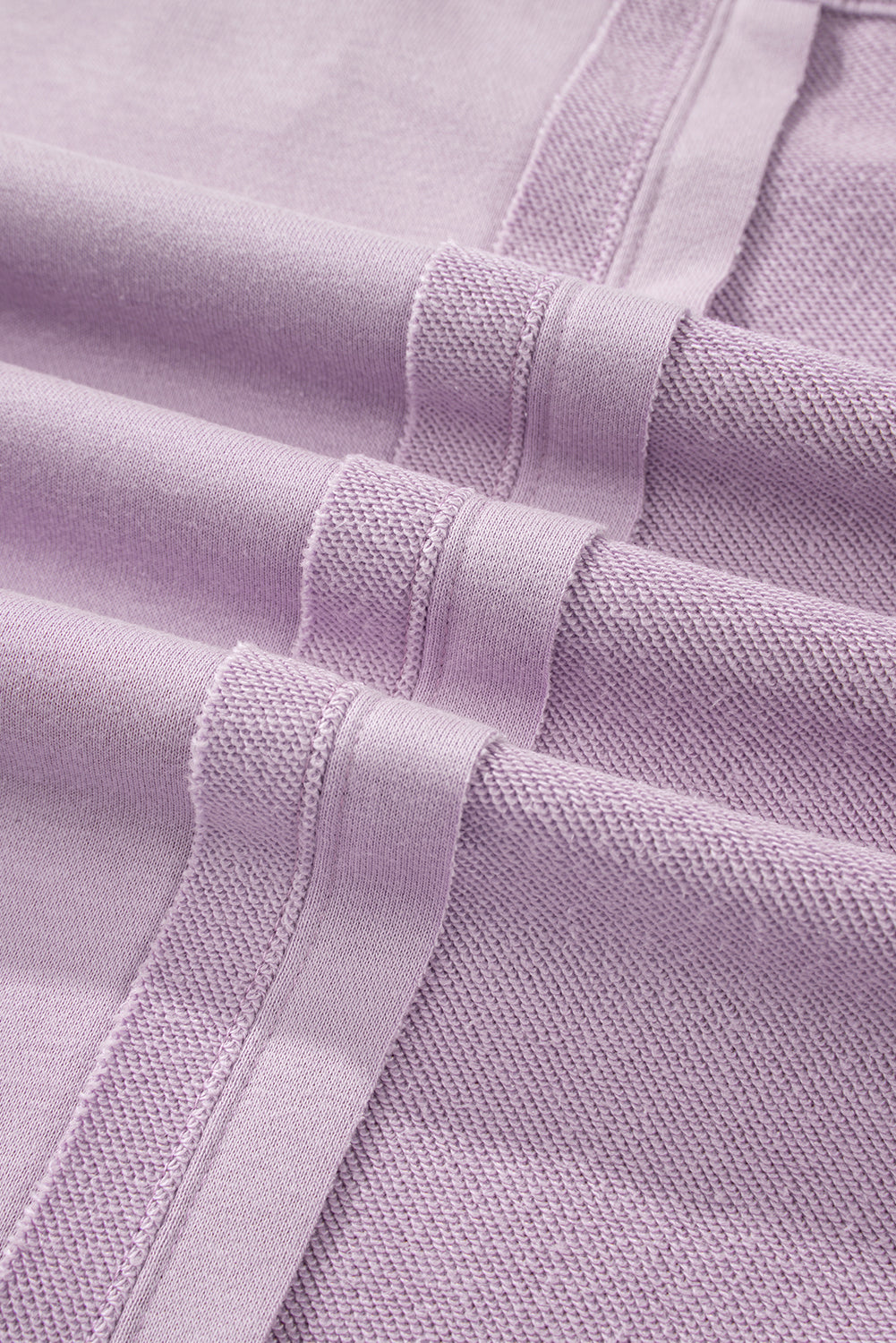 A person with long hair is seen from the back wearing the Orchid Petal Knit Crochet Exposed Seam Ribbed Trim Sweatshirt, blue jeans, and a brown crossbody bag.