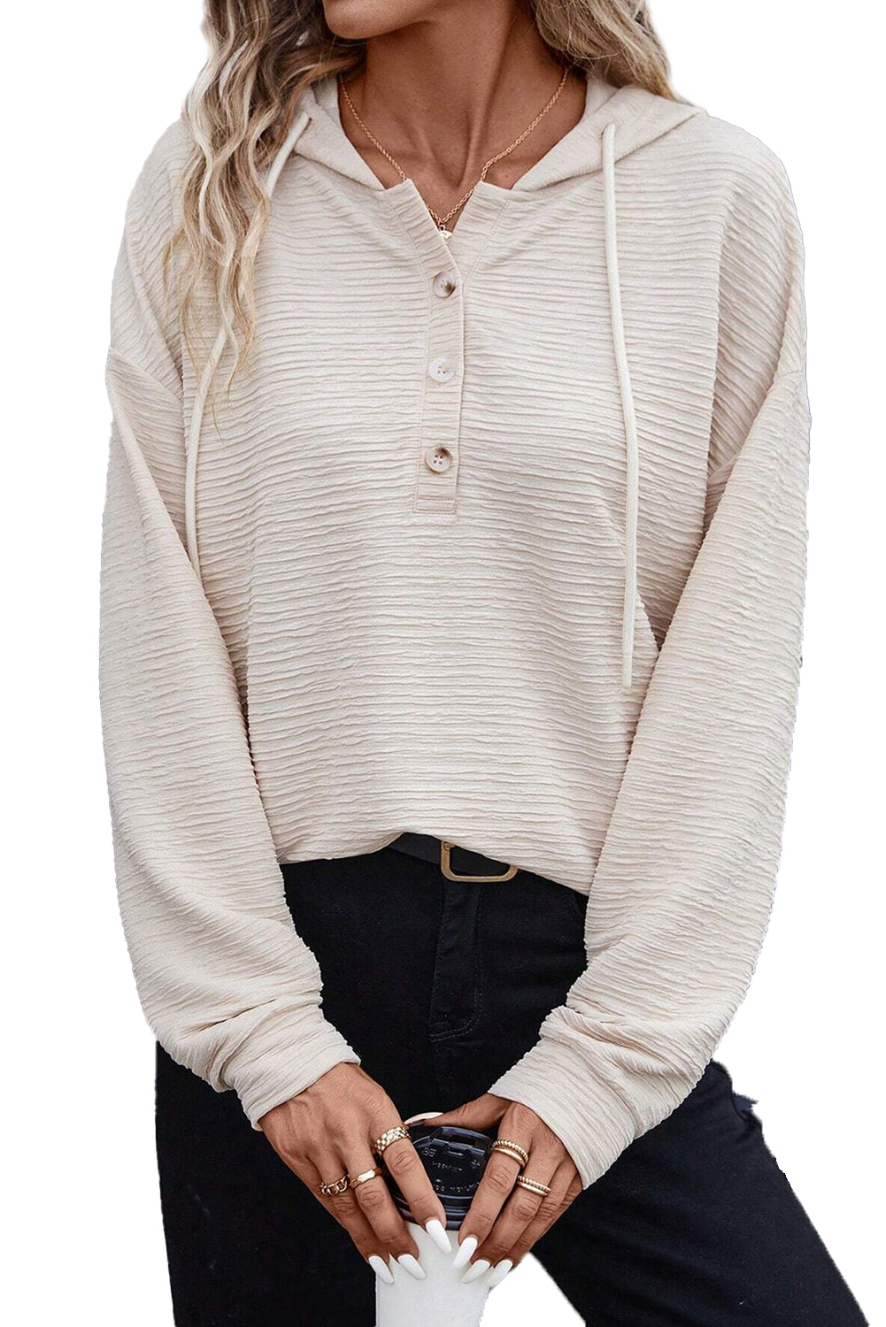 A person is wearing an Apricot Solid Color Textured Drawstring Henley Hoodie and black pants. They are holding a beverage cup and have rings on their fingers. Their face is not visible, making it perfect for casual occasions.