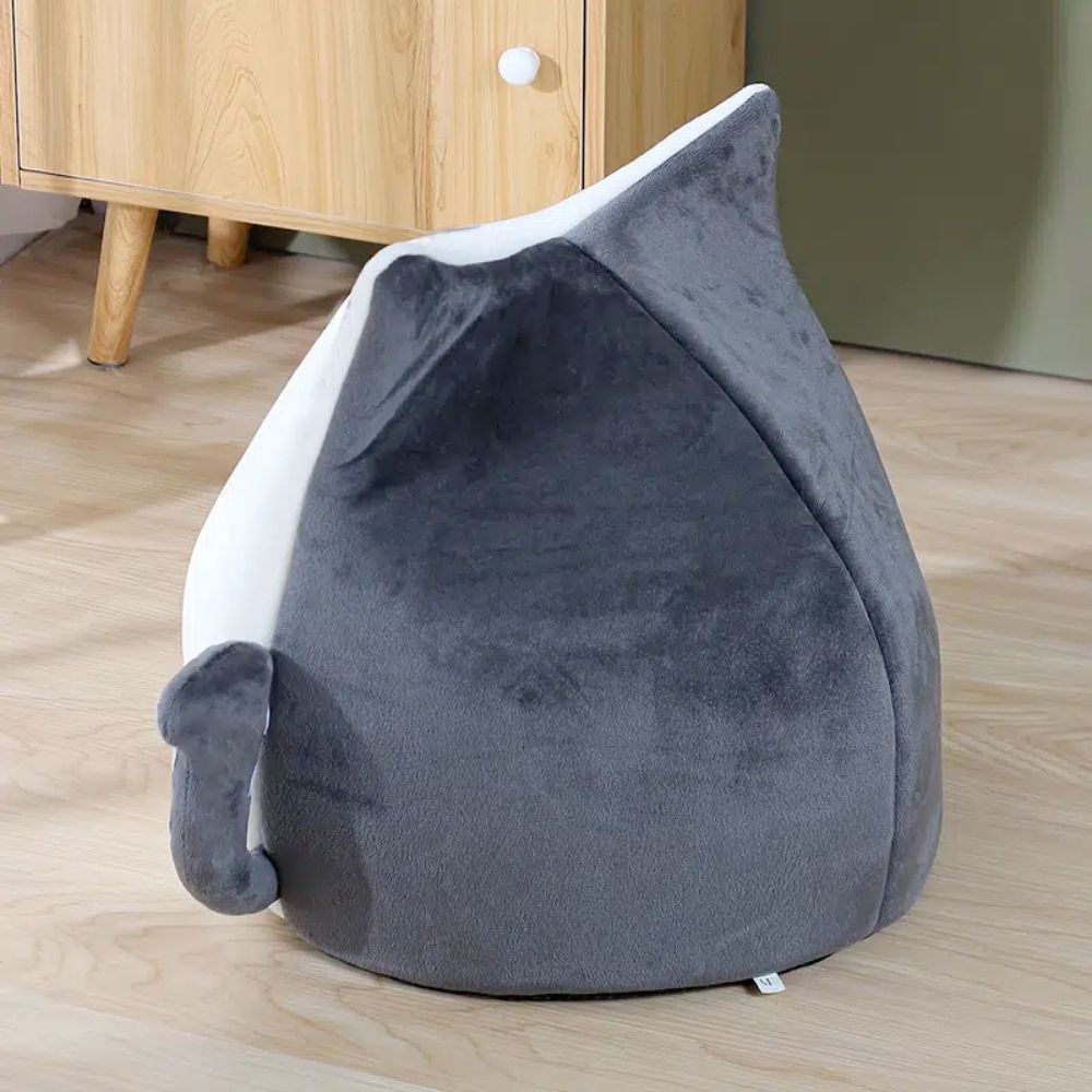 An Adorable Cat Shape Pet House nestled in a cozy pet house designed like a cat shape bed, enjoying the soft spot.