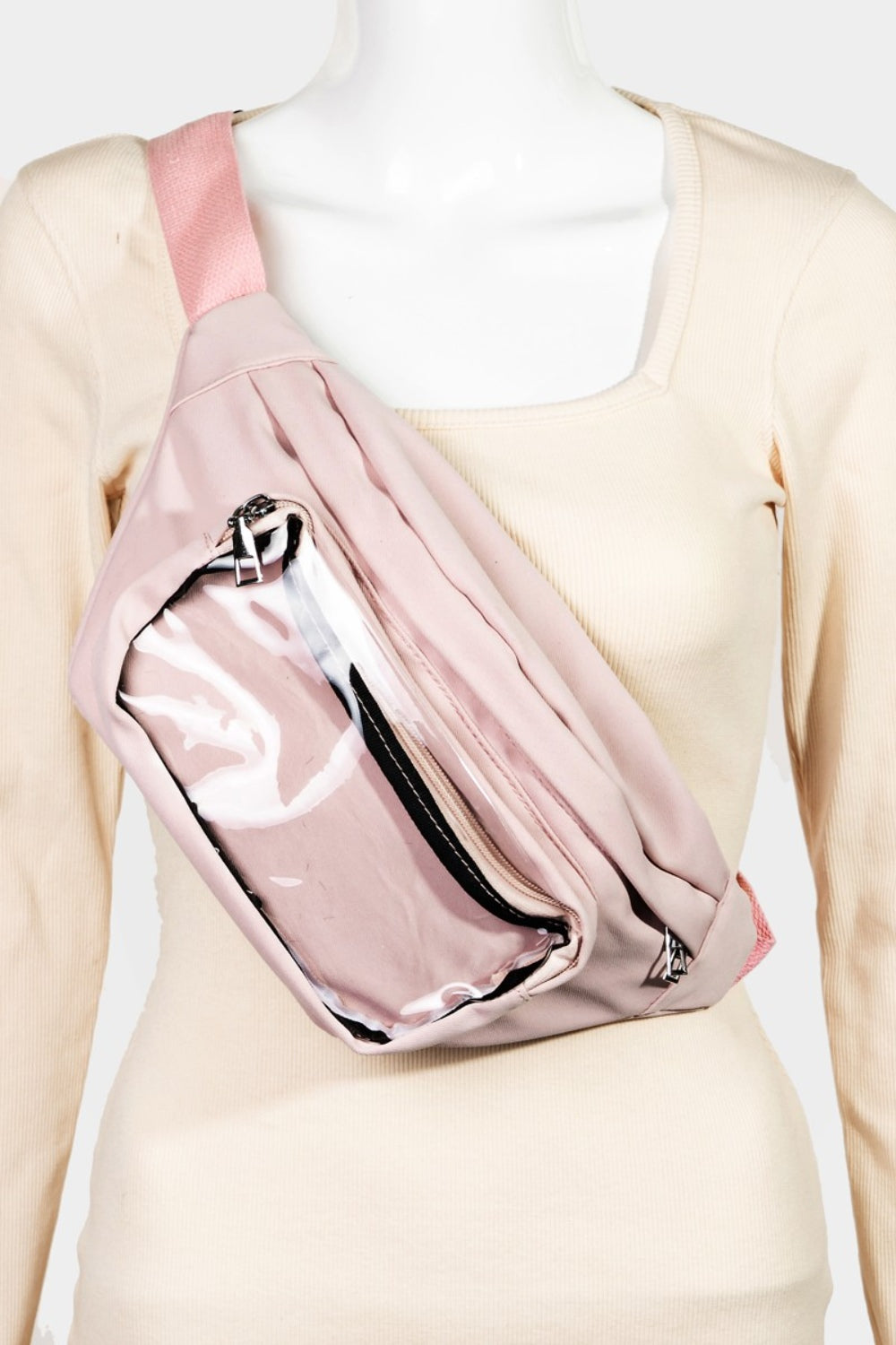 A woman wearing a black sleeveless top and beige pants showcases the Fame Adjustable Strap Sling Bag, styled as a pink crossbody fanny pack, against a light background. Her long, wavy blonde hair complements the look of this versatile accessory, ideal for everyday use.