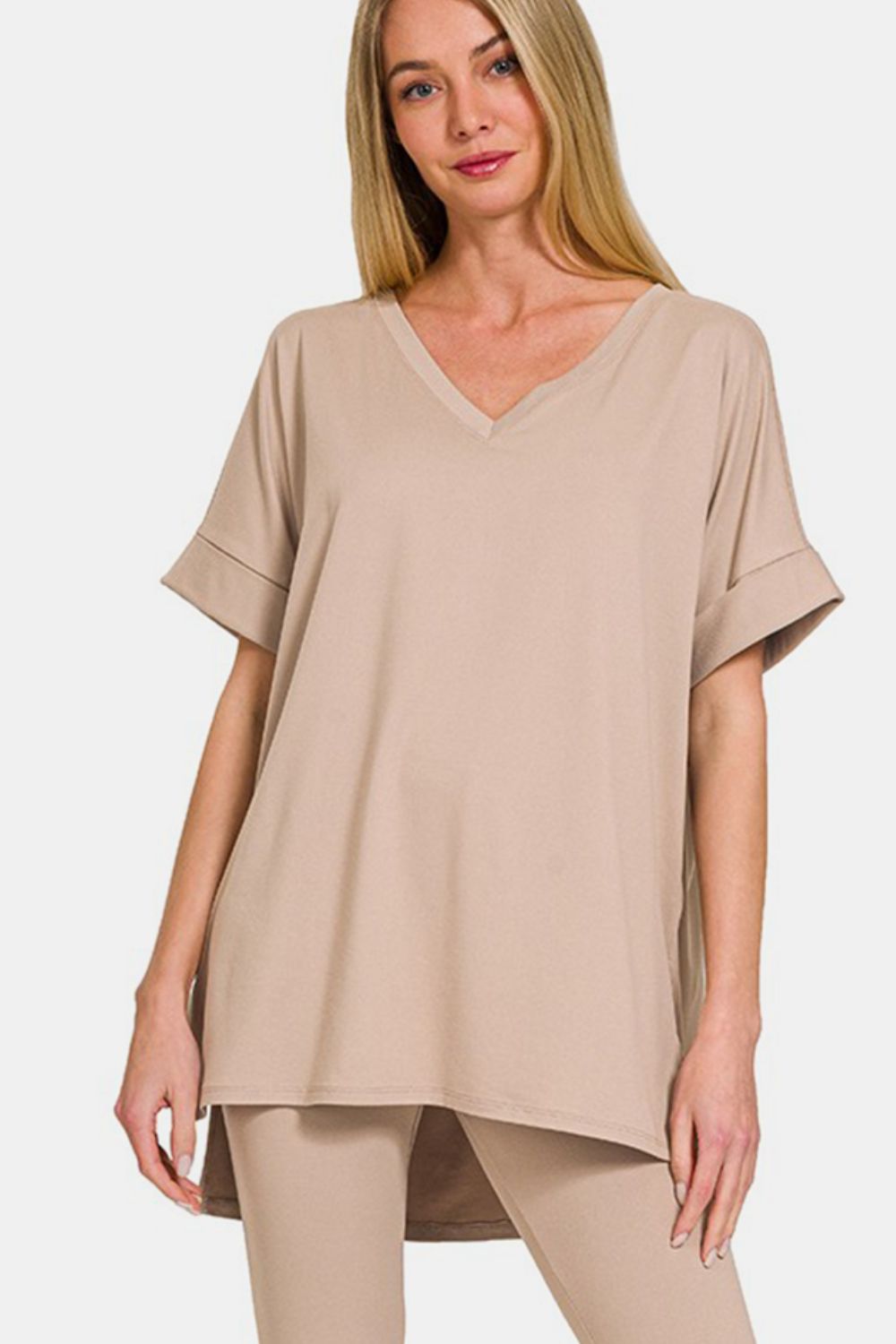 A person exudes comfort and style in the Zenana Full Size V-Neck Rolled Short Sleeve T-Shirt and Leggings Lounge Set, standing against a plain white background.