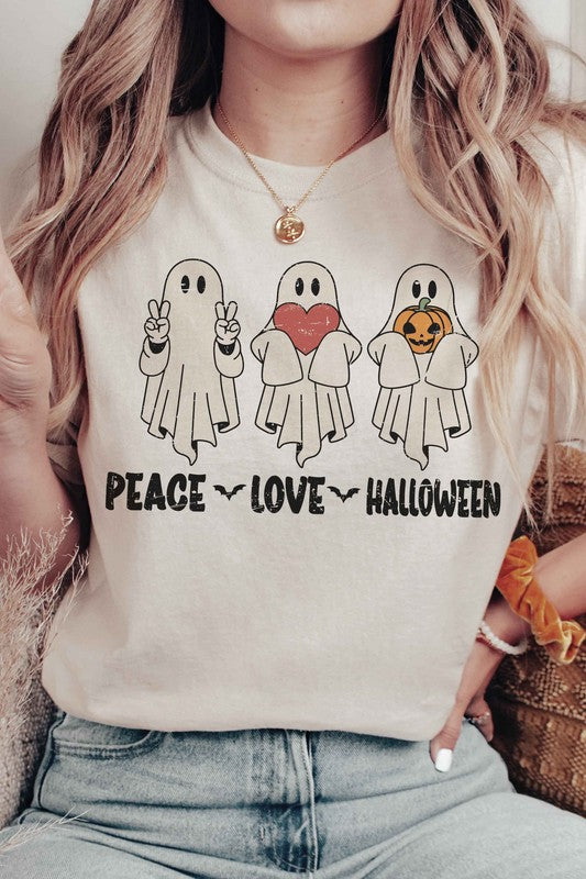 A person wearing the PEACE LOVE HALLOWEEN Graphic Tee, which features three cartoon ghosts—one making a peace sign, another holding a heart, and the third with a pumpkin—along with the words "PEACE LOVE HALLOWEEN" printed underneath.