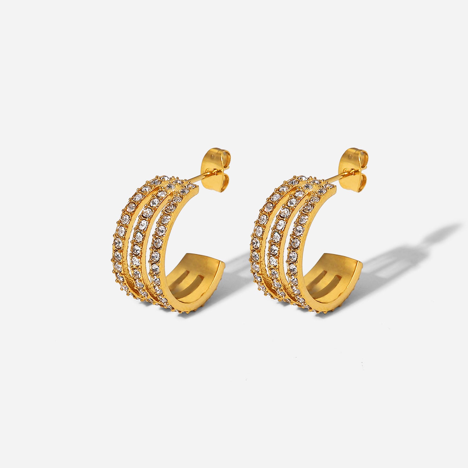 The Stainless Steel Inlaid Zircon C-Hoop Earrings perfectly blend elegance, featuring a triple row of small, clear gemstones on each gold-plated hoop.