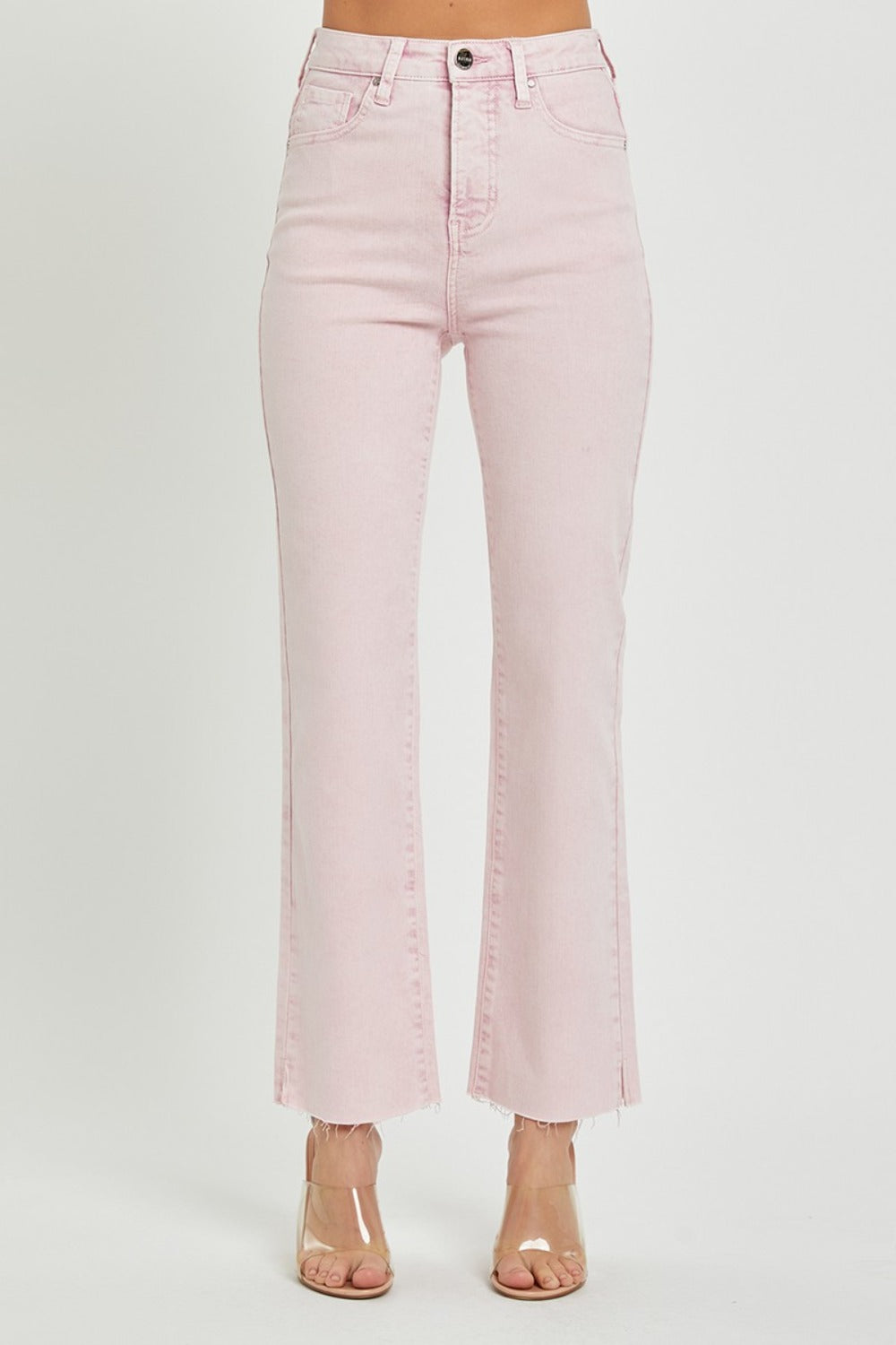 Person wearing RISEN Full Size High Rise Tummy Control Straight Jeans in light pink with a raw hem and clear heeled shoes against a plain white background.