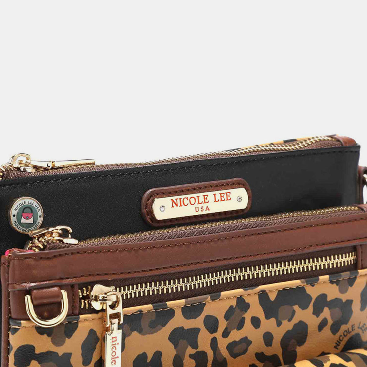 The Nicole Lee USA Leopard crossbody bag is made from vegan leather and showcases a leopard print design. It features a front pocket, a zippered closure, gold-tone hardware, brown trim, and a black panel at the top that is embellished with a brand label.